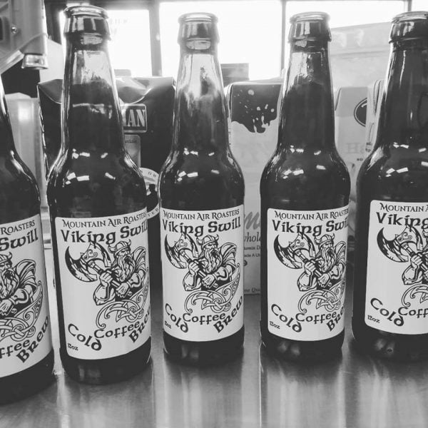12 oz dark brown glass bottles with Mountain air roasters cold brew viking swill in them, viking with horns and a big ax on sticker