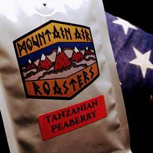 Tanzanian Coffee Air Roasted coffee bag with a nautical compass on it, with a Tanzanian Pea Berry sticker on the bag